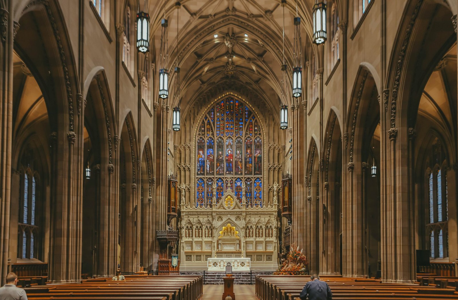 a large cathedral with pews and stained glass windows