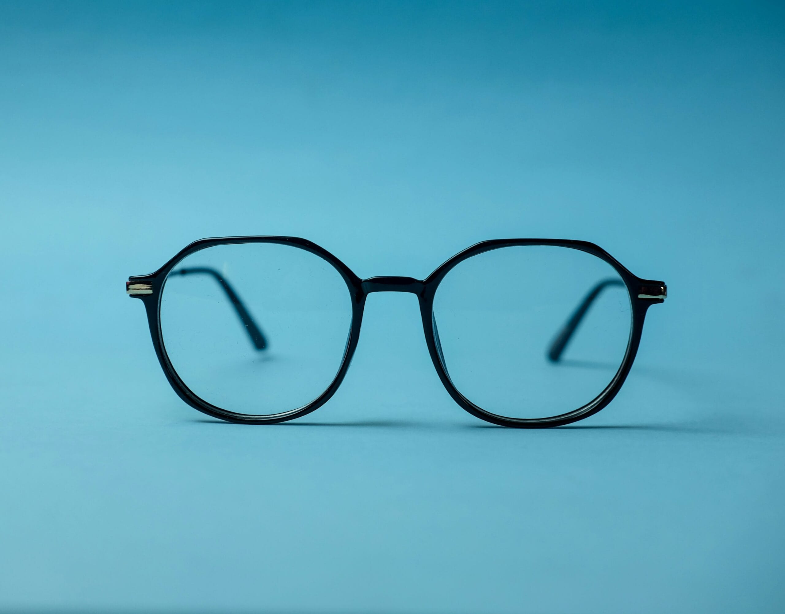 black framed eyeglasses on white surface